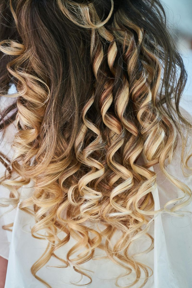 Blonde curly ombre hair showcasing colour vibrancy achieved with Shiseido Luminoforce treatment at EDITION Salon Pattaya